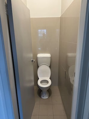 A small, narrow bathroom with a white toilet, a visible door handle, and tiled walls. - 5 mins to Central Sydney
Lord Raglan Hotel (Alexandria)
