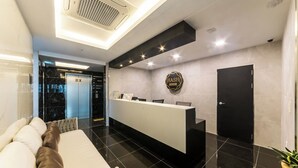 A hotel reception area with a reception desk, a black door, and a sign that reads 'HASH HOTEL'. - Suwon Hash Hotel (Suwon)
