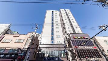 A multi-story building with a prominent sign for 'HASH HOTEL' at the top.