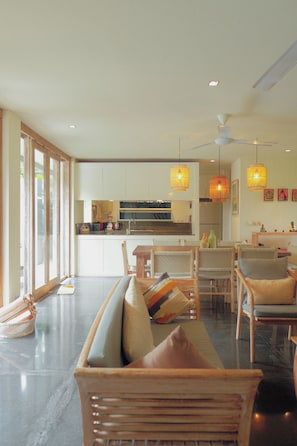 Un salón amplio con sofá, mesa de comedor, sillas y una cocina al fondo.