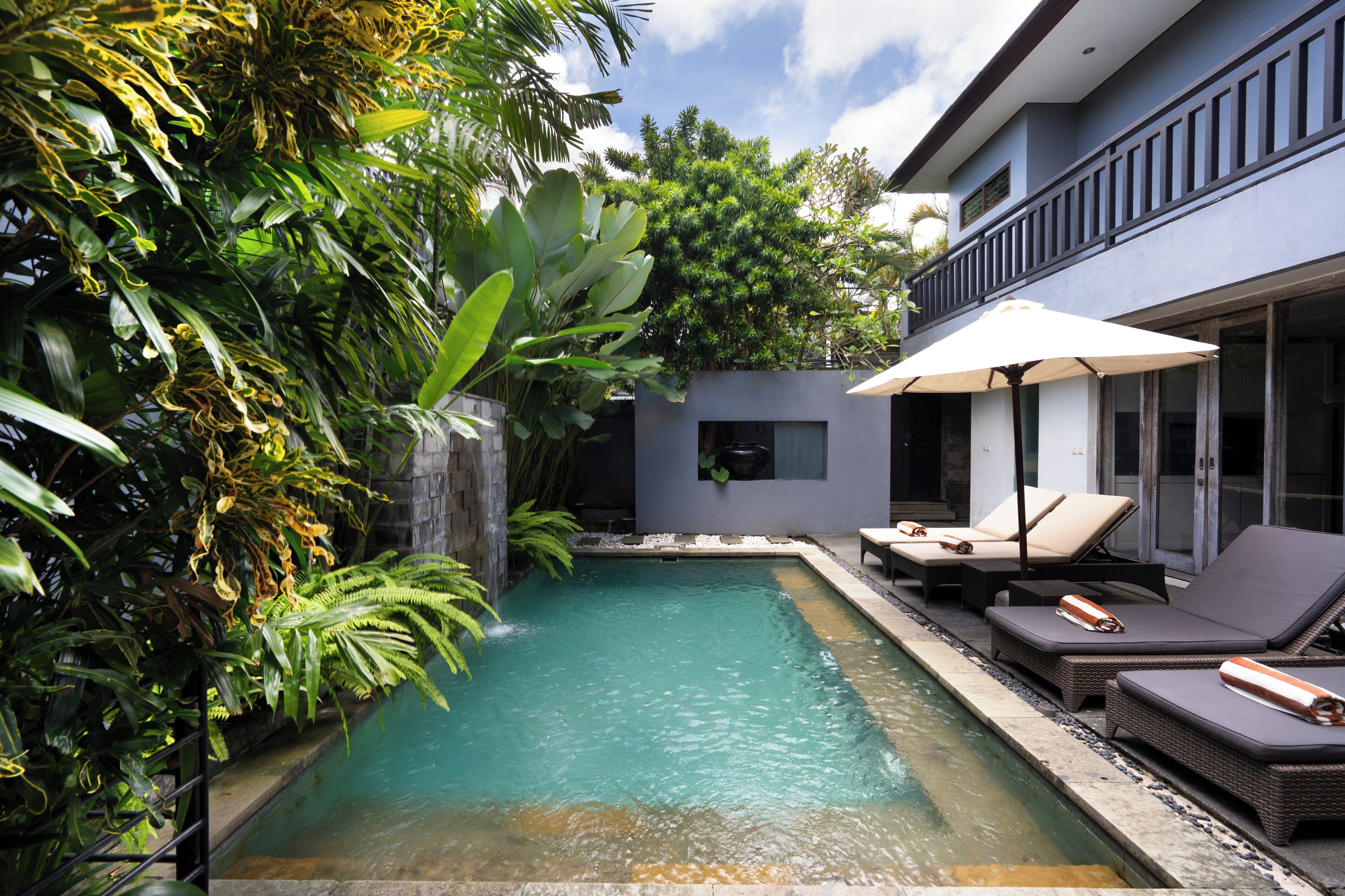 A pool area with lounge chairs and a waterfall feature.