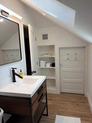 A modern bathroom with a white vanity, a mirror, and a built-in shower. - Sonoma Sky Suite:  Private Hot Tub, Outdoor Space, Entrance….couples getaway. (Sonoma)