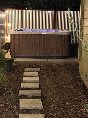 A wooden hot tub with a metal frame, surrounded by a wooden fence and a stone pathway leading to it. - Sonoma Sky Suite:  Private Hot Tub, Outdoor Space, Entrance….couples getaway. (Sonoma)