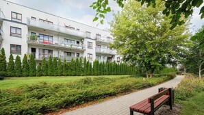 A pathway leading to a building with a row of windows and a bench. - Royal Wilanów Charming Apartment (Warszawa)
