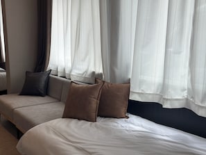 A hotel room with a bed, a sofa, and curtains. - KATAWARE  About 10 minutes to Shinjuku | 3-minute walk from Numabukuro Station | Private 1LDK | 60 ㎡ | Accommodates up to 6 people | 3-minute walk to a supermarket and convenience store (中野区)