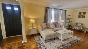 A living room with a sofa, a coffee table, a side table, and a patterned rug.