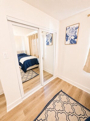A bedroom with a bed, a sliding door, a patterned rug, and two framed floral artworks on the wall. - The Ascended Retreat (Dallas)