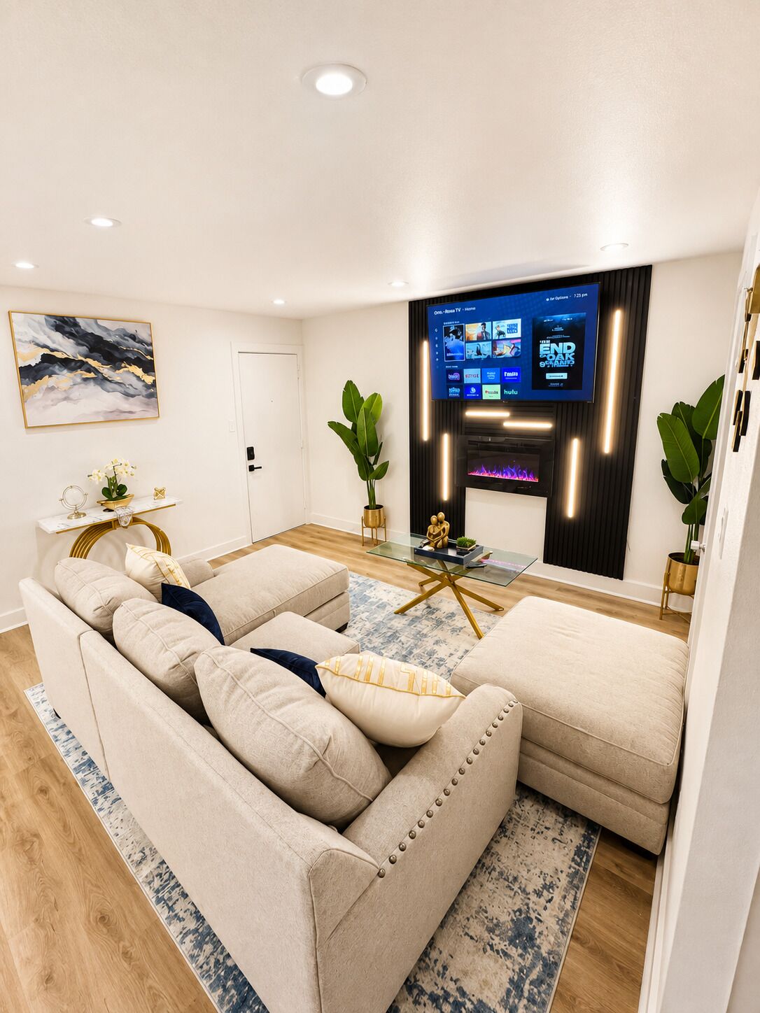 Ein modernes Wohnzimmer mit einem beigefarbenen Ecksofa, einem Glastisch und einem flachbildfernseher an der Wand.