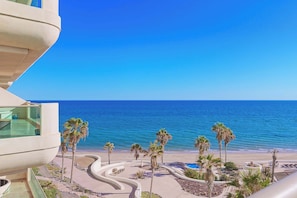 A beachfront property with a curved pathway, palm trees, and a pool area. - Tessoro 204 Beachfront 3BR Luxury Escape (Las Conchas)
