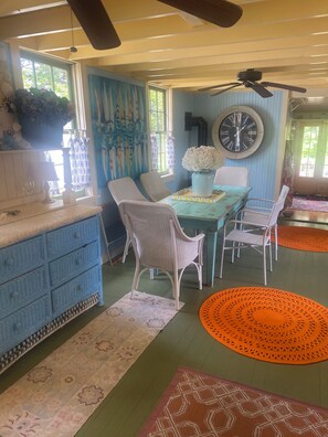 A dining area with a table, chairs, and a clock on the wall. - Princess of The Lake (Caroga Lake)