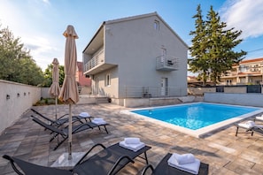 A modern two-story building with a swimming pool, outdoor seating, and a covered area with umbrellas. - Holiday House Lana With Pool, Biograd na Moru, Croatia (Biograd na Moru)