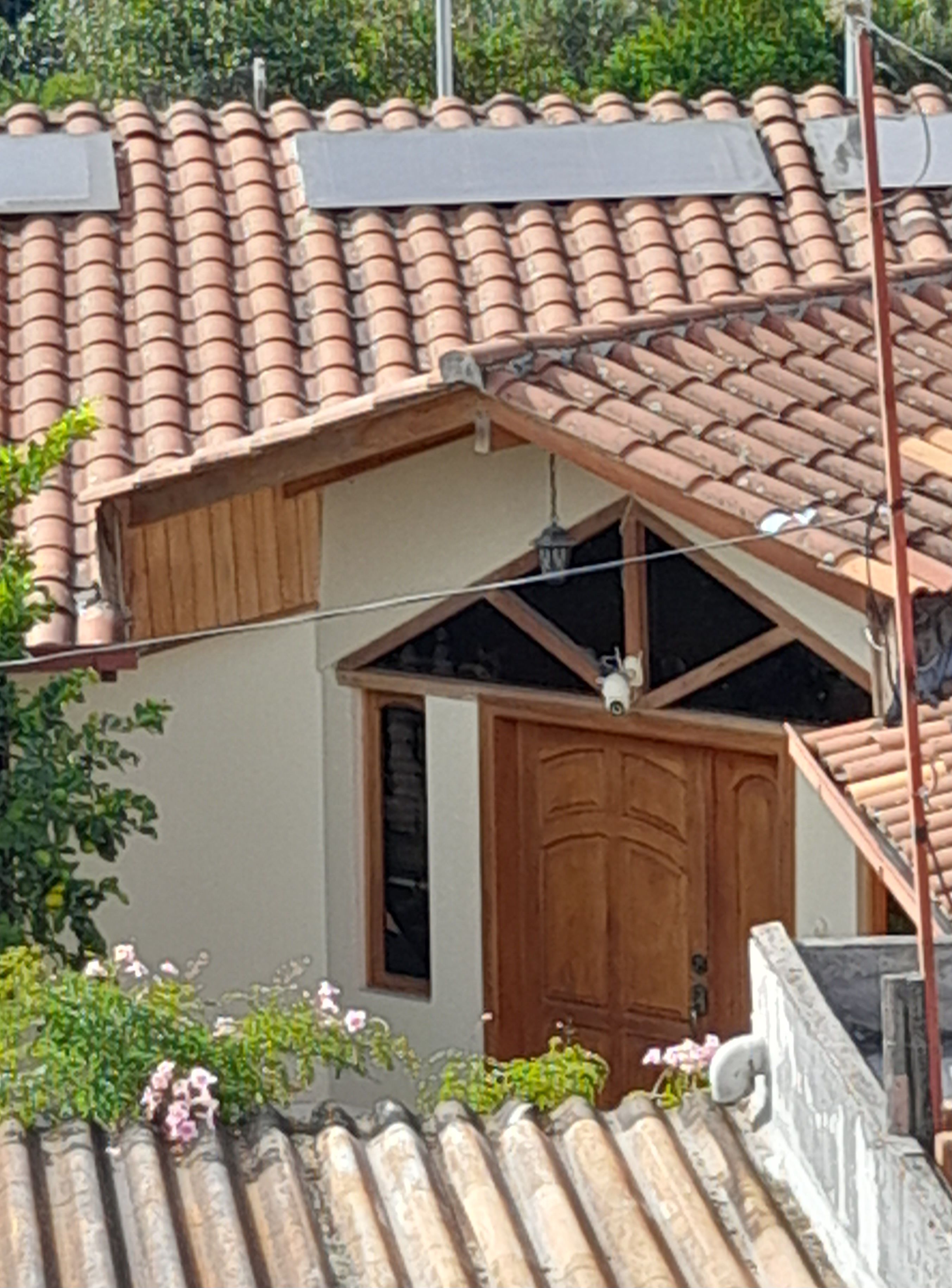 A building with a tiled roof, a wooden door, and a window.