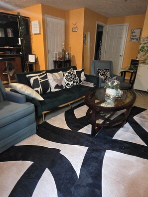 A living room with a sofa, armchairs, a coffee table, and a patterned rug. - Private Basement Suite with Kitchen & Separate Entrance (Upper Marlboro)