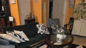 A living room with a sofa, chairs, a coffee table, and a patterned rug.