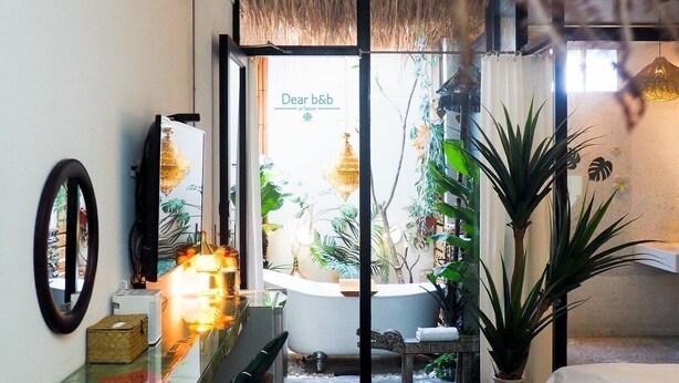 A bathroom with a bathtub, a mirror, a sink, and a potted plant. - FAS Glass House II - Color Space BnB (Xincheng)