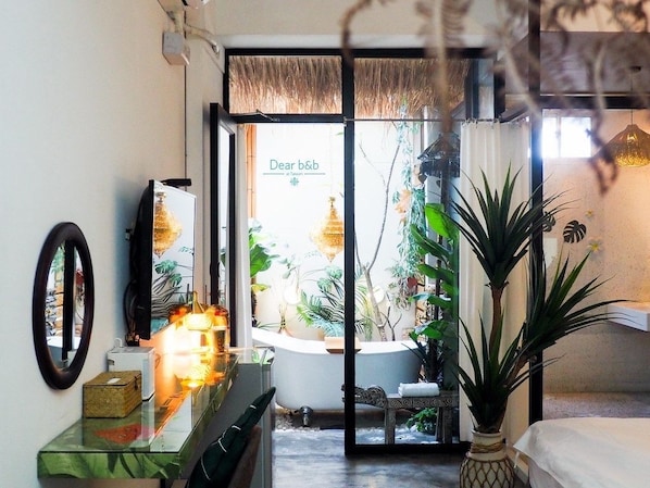 A bathroom with a bathtub, a mirror, a sink, and a potted plant. - FAS Glass House II - Color Space BnB (Xincheng)