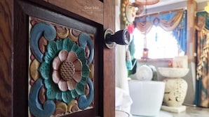 A wooden door with a decorative metal flower design.