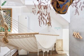 A hammock in a room with a refrigerator, a hanging plant, and a wooden chair. - FAS Glass House II - Color Space BnB (Hualien County)