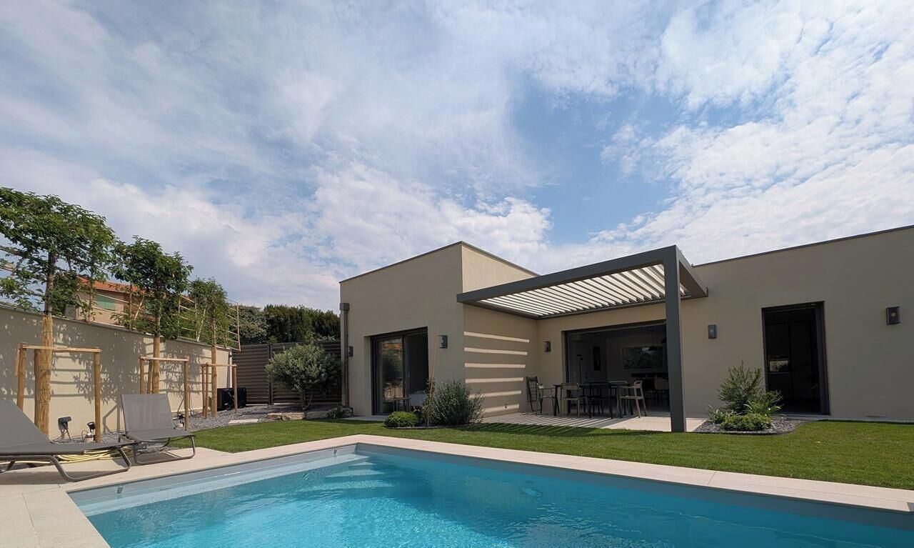 Une maison moderne dotée d’une piscine, d’un patio couvert et d’une pelouse bien entretenue.