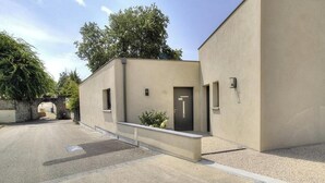 Un bâtiment moderne à la façade plate, doté d’une petite entrée et d’une allée pavée.