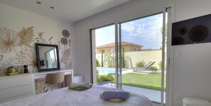 A bedroom with a bed, a desk, and a large window. - Vrbo Property (MILLERY)