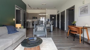 A modern living room with a sofa, a coffee table, and a dining area with a table and chairs. - Landing Amazing 2bd, Courtyard, Clubhouse (Dayton)