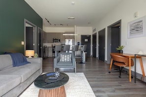 Una sala de estar moderna con un sofá, una mesa de centro y una zona de comedor con una mesa y sillas.