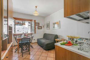 Een kleine keuken met een eethoek, een bank en een tafeltje met eten.