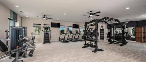 A gym with treadmills, weight machines, and a squat rack.
