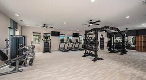 Ein Fitnessstudio mit Laufbändern, Kraftgeräten und einer Hantelbank.