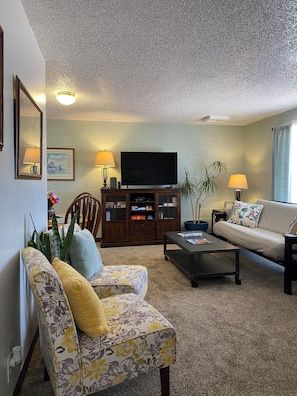 A living room with a sofa, coffee table, TV, and a cabinet. - Cozy 3-bdrm, 1 bath apt. minutes away from Horseshoe Bend and Antelope Canyon! (Page)