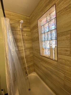 A bathroom with a shower, a bathtub, and a stained glass window. - Cozy 3-bdrm, 1 bath apt. minutes away from Horseshoe Bend and Antelope Canyon! (Page)