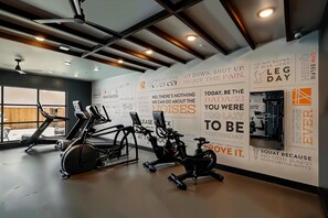 Ein Fitnessraum mit Trainingsgeräten und motivierenden Sprüchen an der Wand.