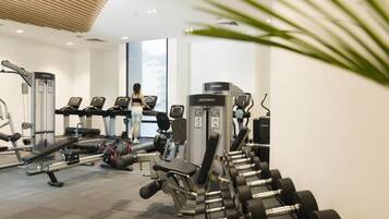 Ein Fitnessstudio mit Trainingsgeräten, Laufbändern und Kurzhanteln.