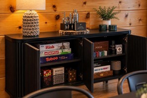 A wooden cabinet with various board games and a cocktail recipe card. - Indoor Pool • Hot Tub • Theater • Games • Views (Sevierville)