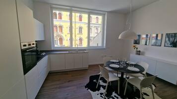 A modern kitchen with a window view, a dining area with a cowhide rug, and a table set for four.