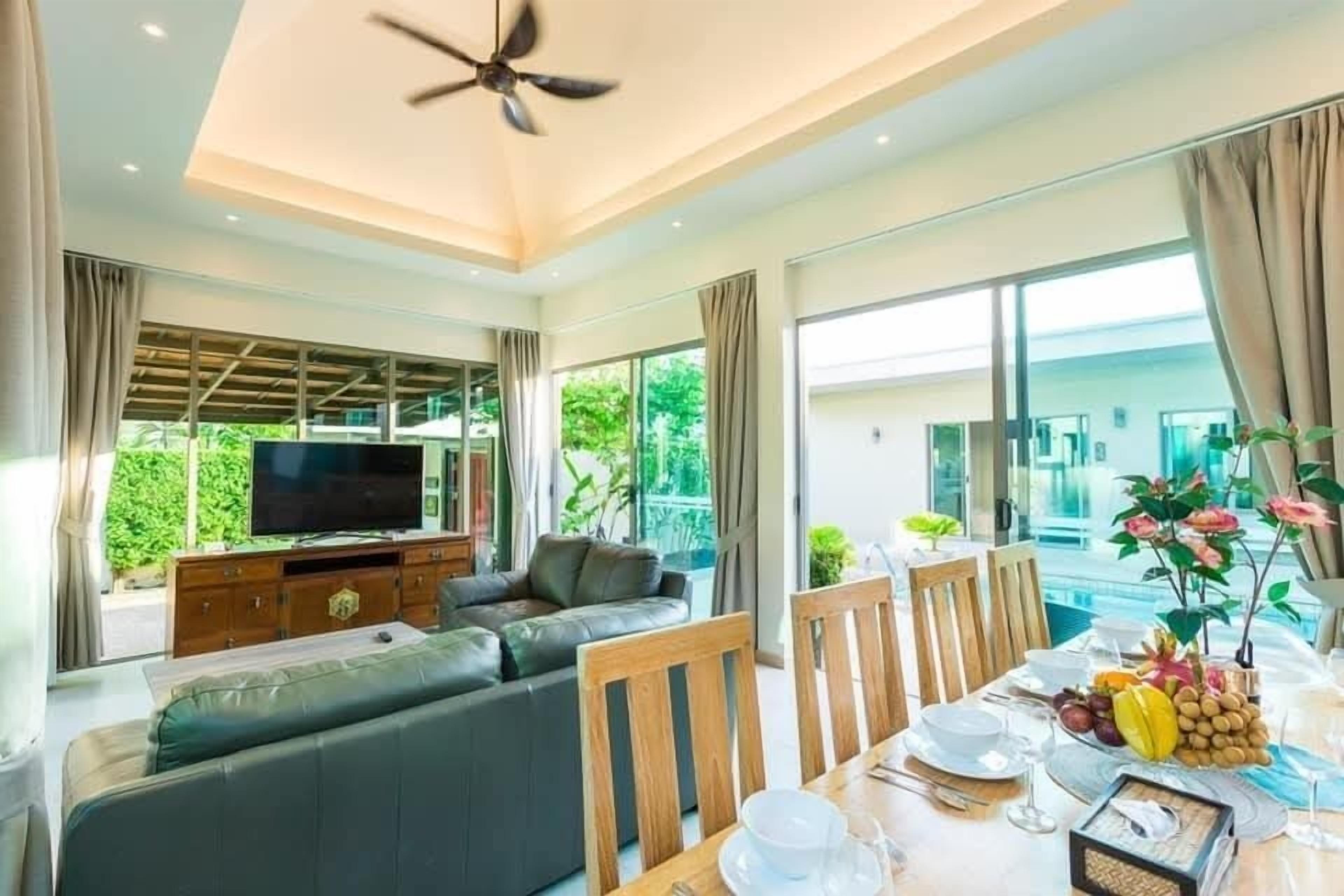 A modern living room with a sofa, dining table, and a TV.