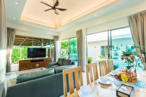 Una sala moderna con un sofá, una mesa de comedor y una televisión.
