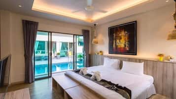 Habitación de hotel con una cama grande, un banco, un ventilador de techo, un cuadro y vistas a una piscina a través de una puerta de cristal.