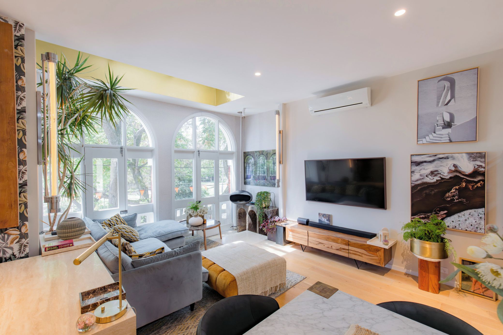 A modern living room with a sofa, TV, and artwork.