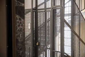 A metal gate with a keyhole, part of a building's exterior. - Hearth City Center Milan (MI)