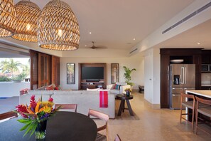 Un salon moderne avec un canapé, un téléviseur et un coin repas.