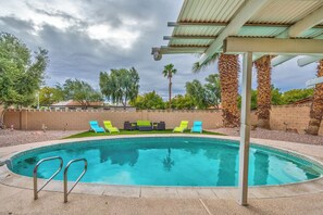 A swimming pool with a pergola overhead, surrounded by palm trees and a brick wall. - Las Vegas Boutique Villa with Pool & BBQ (Las Vegas)