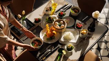 A table set with various dishes, utensils, and a book titled 'LUXURY HOUSE'.