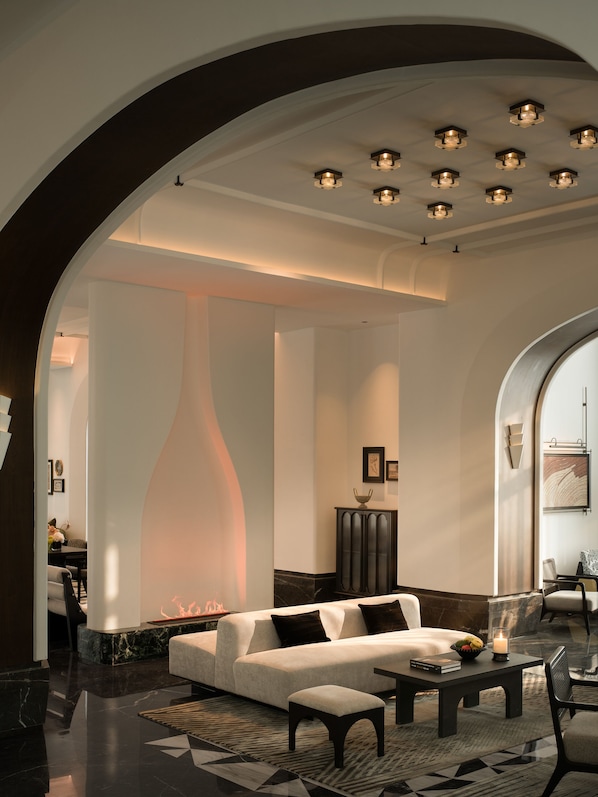 A modern interior with a sofa, coffee table, and a fireplace.