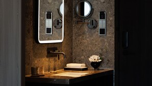 Een moderne badkamer met een grote spiegel, een wastafel, een handdoekrek en een toilet.