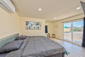 A bedroom with a bed, a painting, a window, and a view of the outside. - new luxury house 12 min from strip (Las Vegas)