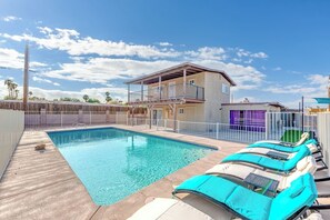 A swimming pool with lounge chairs, a wooden deck, and a two-story building with balconies. - villa for families pool/jacuzzi/playground (Las Vegas)