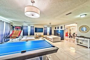 A spacious living area with a pool table, a sofa, a television, and a fireplace. - villa for families pool/jacuzzi/playground (Las Vegas)