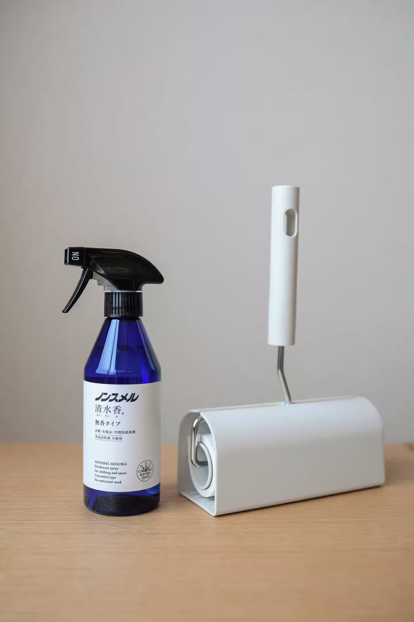 A blue spray bottle with a black nozzle and a white charging station.